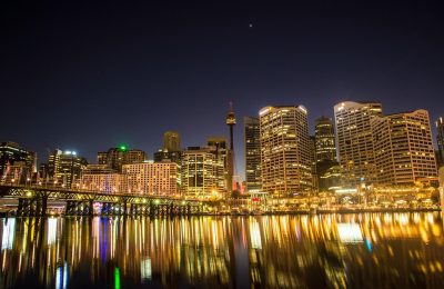 夜晚城市天台上两个人并肩站立，远处楼宇灯光点点，画面色调偏蓝，气氛安静克制